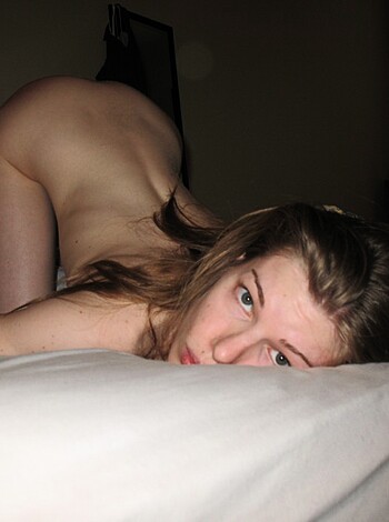 This image is of a nude bitch who's got her pussy wide open for all to see, looking straight at the fucking camera like she owns the place.