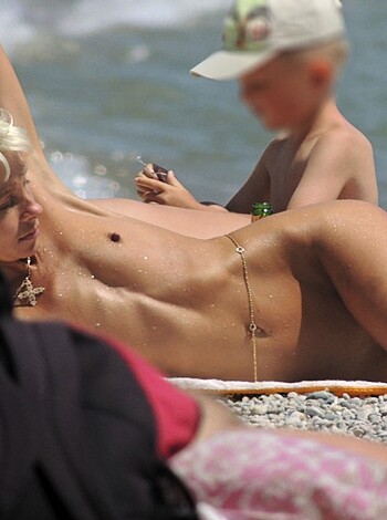 Here's a babe with a perfect titty-fuckin' body laying out in the sun, wearin' a delicate string of fuckin' pearls around her neck. She looks like she's ready to get fucked and pounded by some big dick sailor or something. You know what I'm sayin', motherfucker?