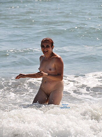 A naked bitch in swimming trunks wading into the water like a dumb whore.