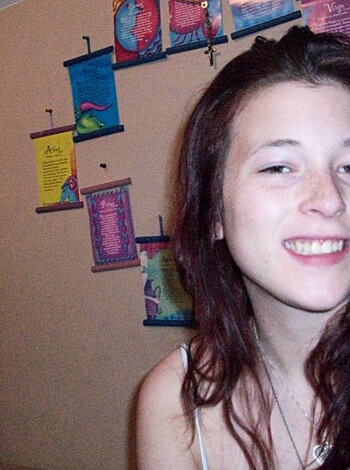 An attractive babe posing for a picture, giving a shit-eating grin.