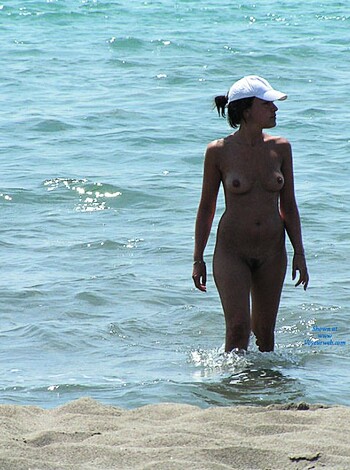 Vulgar description: A chick strollin' on the shore in just a fucking bikini bottom, with no goddamn top!