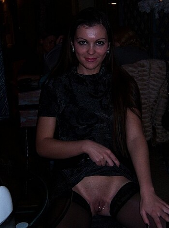A chick with her cunt showing while sitting at a table.