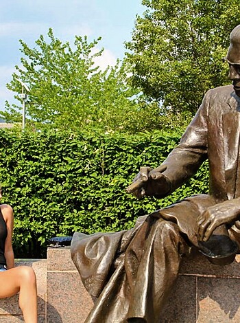 A naked chick flashes her tits at a MLK statue while sporting some sexy lingerie.