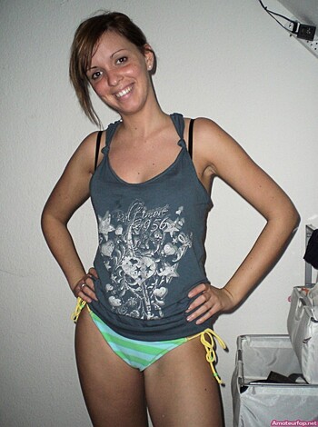 A naked chick wears a cropped shirt and some string bikinis.