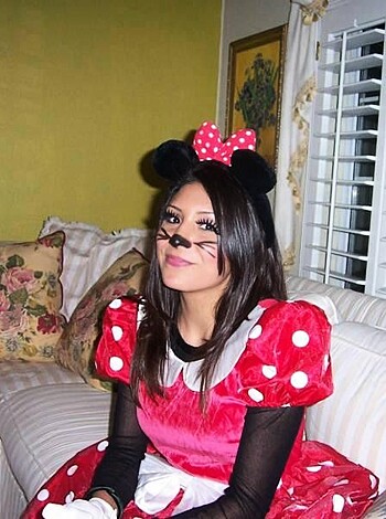 Image of hot babe in mouse costume with her ass resting comfortably on the couch while she flips through porn magazines.