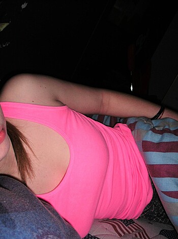 Here's a hot chick lying on her back in a pink t-shirt with some tight braces on her wrist. She looks like she wants some action, but you better be quick cause I can see straight through her clothes to that fine ass of hers.