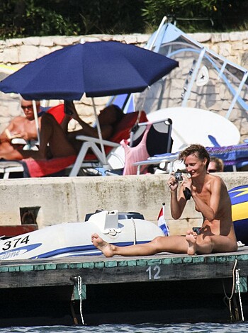 Two dudes on the dock, one snapping pics of the other dude’s ass.