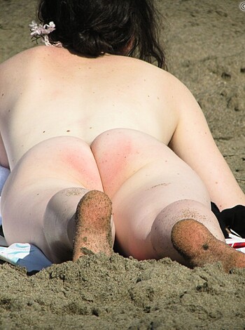 "Bare-assed broad baking her booty on the sand."