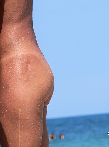 Here's a fuckin picture of someone's tight ass on the beach, wearing nothing but a skimpy bikini.