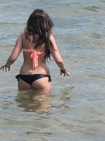 Here's the shot: A hot chick's bum packed tightly into some string bikini bottoms, as she lays out on the sandy shore.
