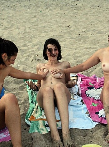 A photo of four fat chicks sitting ass-naked on beach towels, showing off their flabby tits and cellulite-ridden thighs.
