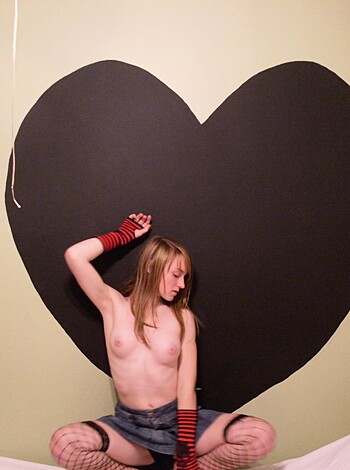 "Here's a pic of some chick with titties showing, standing in front of a huge fucking heart that's been carved outta some wall. I dunno why she did it, but at least her boobs look good."
