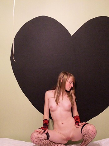 Vulgar Description:
"Here's a fuckin' pic of some hot babe, bustin' out her titties and pussy for the camera, posein' with a lame-ass heart-shaped cardboard cutout in the background. What a waste."
