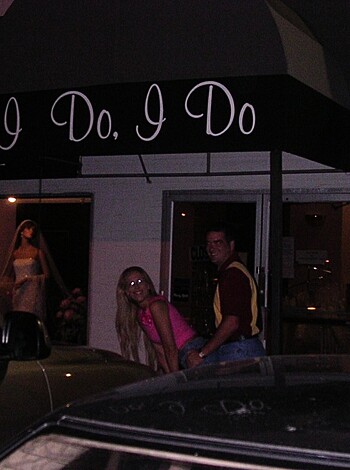 The fucking couple is standing in front of the motherfucking store.