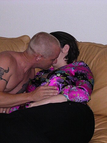 A nude man and woman are lying together in a romantic embrace.