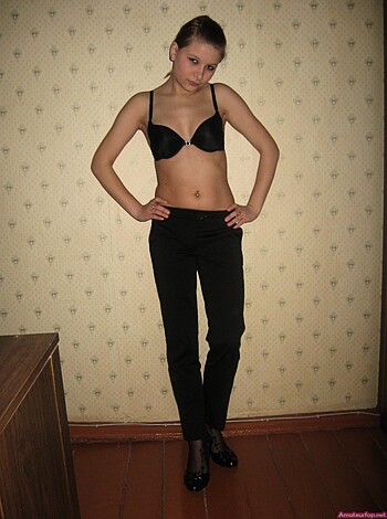 Busty blonde chick with black lacy undies and jeans striking a pose for the camera.