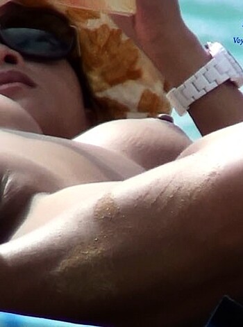 "Here's a photo of some fuckin' hot, sexy ass chick layin' out on the beach with her tits almost poppin' outta her bikini top, while her dude boyfriend is naked from the waist down, showin' off his shlong for all to see."