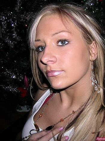 "Fuckin' hot bitch playin' with tits while smilein' for dumbass camera with a fuckin' Christmas tree behind her, lame-ass caption."