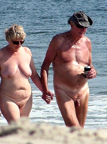 Vulgar description: "Two f*cking nude ass adults stroll down the sandy shore, showing their bare skinny bodies and dicks."