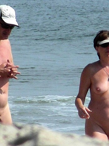 A couple fucking on the shore with their dicks out and vaginas showing.