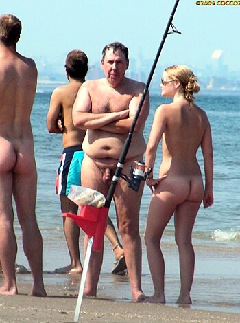 A bunch of naked dudes hangin’ out on the sandy shores, their junk and asses exposed for all to see.