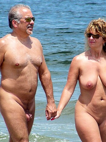 Here's a fuckin' picture of two dirty ass bitches and dudes strollin' around naked on the beach with their dicks and tits flappin' in the wind, while the sun's shinin' down on 'em like they ain't got no clothes on.
