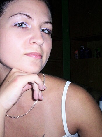 Vulgar description: This image shows a hot bitch with blue contacts on her eyes and some fake shit on her face, wearing dainty earrings that match her tight-assed hair while she leans back in some chick's car.