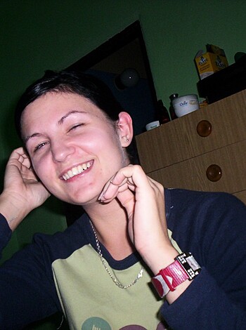 "Fucking hot chick with a cute smile, showing off her boob job while flashing the finger."