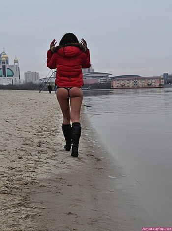 Here's the description of a lady with a fat ass wearing only red boots and a puffy jacket while walking on the sandy shore like a fucking slut.