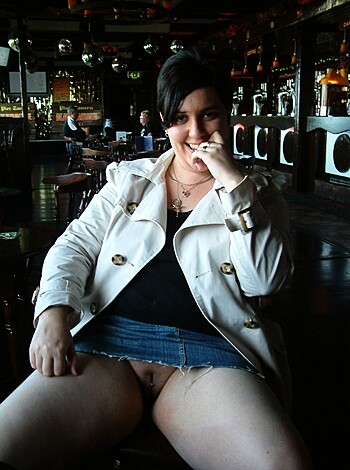 The caption for this image is a clear description of the scene, wherein a young woman is seen sitting with her underwear partially exposed from beneath her shorts, resulting in a vulgar, yet factual representation of the situation.