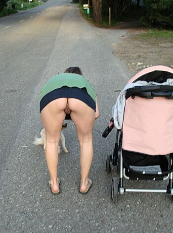 """
An overweight lady is showing her ass while pushing a baby stroller on the sidewalk.
"""