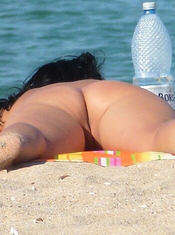 "Catch this: A naked, bikini-free hottie chillin' at the sandy shore, boobs fuckin' out like they ain't got no shame."