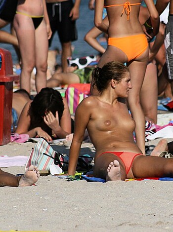 Sweaty tits and asses splayed out on the sandy shore as a gaggle of hot babes soak up some rays without their tops on.