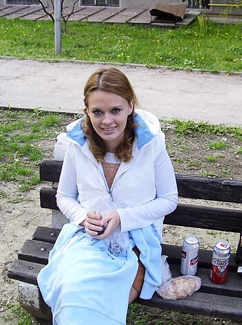 Here's an image of a bitch sittin' on a bench wearing some fucking dress, sportin' a smile for the fucking camera, ya dig?