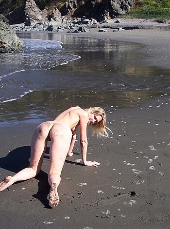 Look at this fuckin' chick sunbathe completely starkers on the sandy shore.