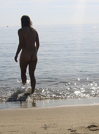 "Here's a hot, hairy-pussied blonde bitch strutting her ass down the sand like she fucking owns it, all while sportin' some nice titties for everyone to gawk at."