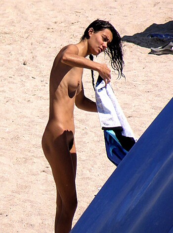 "Hey there dumbass! This here pic shows a smokin' hot chick flaunting her ass naked on the sandy shores of some beach, while rubbing one out. You should probably jerk off to it and call it a day."