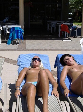 Here's a fucking picture of some hot-assed bitches tanning their fat knockers on the beach, wearing only their coochie snatchers and sunblock.