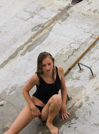 This picture is a topless bitch taking a dump in the lake while sitting on her ass.