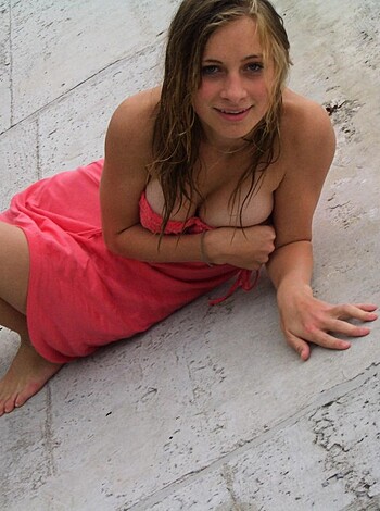 Here's the caption: "A busty chick with tits hanging out, smirkin', and chillin' in a pink towel."