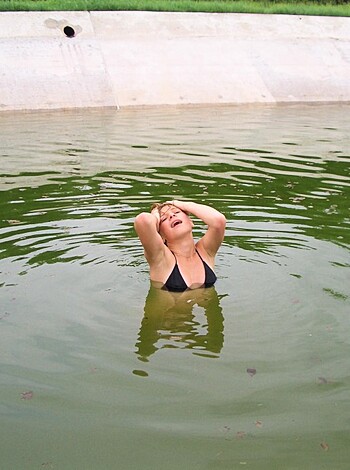 Here's a vulgar description of the image: "A woman's pussy, soaked in filthy water."