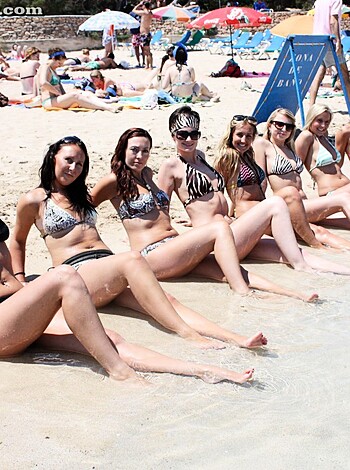 An assortment of cunts in bikinis striking smug selfie poses on the shoreline.