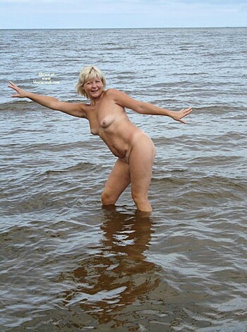 A topless bitch in the sea getting fucking wet, water sloshing over her tits and pussy, saltwater dripping down her perfect curves as she stands there, totally exposed and oblivious to everything except for the goddamn thrill of feeling the ocean's power.