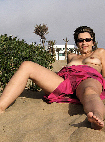 Here's a shot of some hot bitch sunbathing bareassed on the beach, with shades and a massive rack that will make your dick explode.