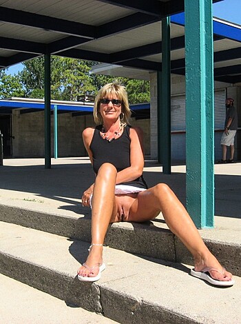A fat broad is seated on some steps.