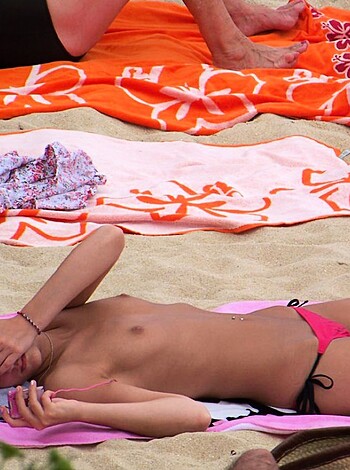"""
A tits-out bitch wearing pink panties on the sandy shore, with her perky nipples standing erect and her juicy ass cheeks jiggling in the sunlight.
""