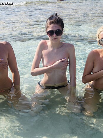 Four tits on a beach, bouncing around like jelly-filled balloons, all squeezed together in a tight pile.