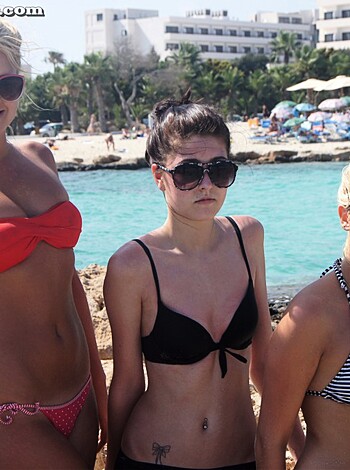 "Fuckin' hot bitches takin' sexy ass selfies on the sandy shore, showin' off their tits n' ass."