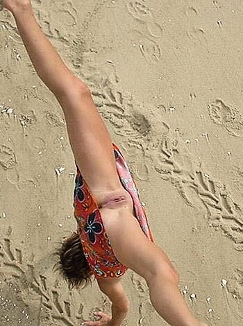 "Hot, naked bitch does fuckin' handstands on the sandy shore."