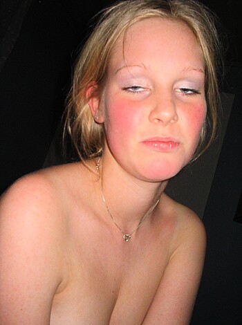 A naked chick with zits on her face, half-opened one eye, looking like shit.